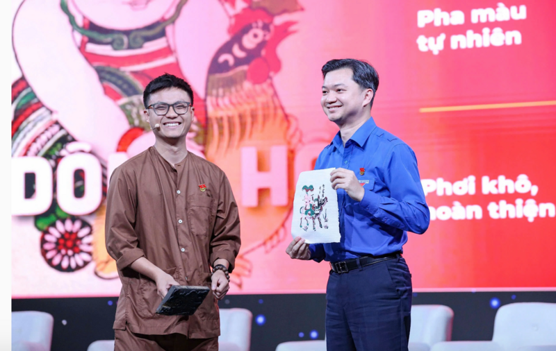 Anh Nguyễn Đăng Hiếu (áo nâu, bên trái) mời Bí thư Trung ương Đoàn Nguyễn Minh Triết trải nghiệm in tranh trên giấy điệp. Ảnh: Tuấn Minh