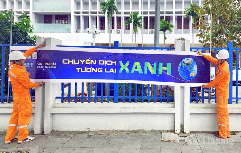 Nhân viên Công ty Điện lực Thanh Hóa treo băng rôn, tuyên truyền hưởng ứng Giờ Trái đất năm 2026. Ảnh: Quốc Anh