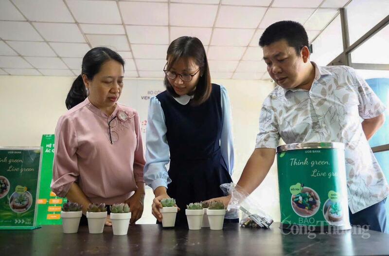 Cán bộ, người lao động Viện Nghiên cứu Cơ khí (Bộ Công Thương) tham gia thu gom pin đã qua sử dụng, bỏ vào thùng để đổi lấy cây xanh.