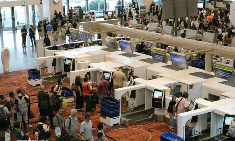 Hành khách xếp hàng tại quầy làm thủ tục ở sân bay Changi, Singapore. Ảnh: TTXVN