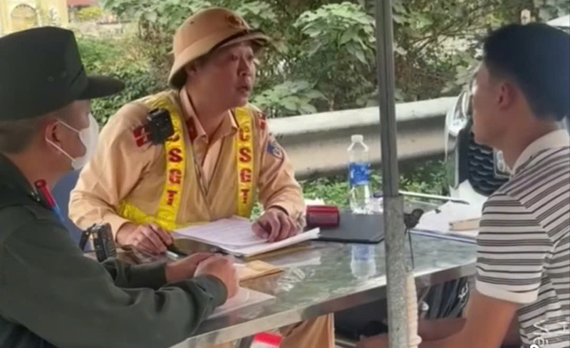 Lực lượng Cảnh sát giao thông làm việc với lái xe (ngồi bên phải) có bằng lái hạng B, điều khiển phương tiện 16 chỗ ngồi. Ảnh: Cục Cảnh sát giao thông