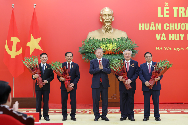 Tổng Bí thư Tô Lâm tặng hoa chúc mừng các đồng chí được nhận Huy hiệu Đảng. Ảnh: VGP/Nhật Bắc