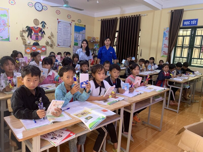 Anh Cải và các bạn tình nguyện viên tặng sách và truyện cho học sinh, thư viện Trường Tiểu học và Trung học cơ sở Suối Bu thuộc Dự án "Thư viện bản em". Ảnh: NVCC.