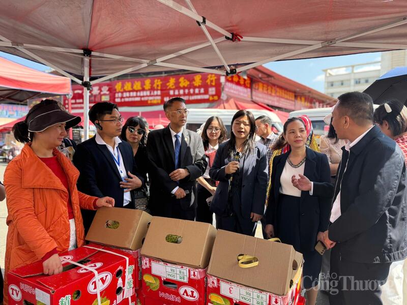 Ông Đặng Ngọc Vượng (thứ hai từ trái sang) cùng đoàn xúc tiến thương mại trao đổi tình hình kinh doanh sầu riêng Việt Nam tại chợ. Ảnh: Minh Trang