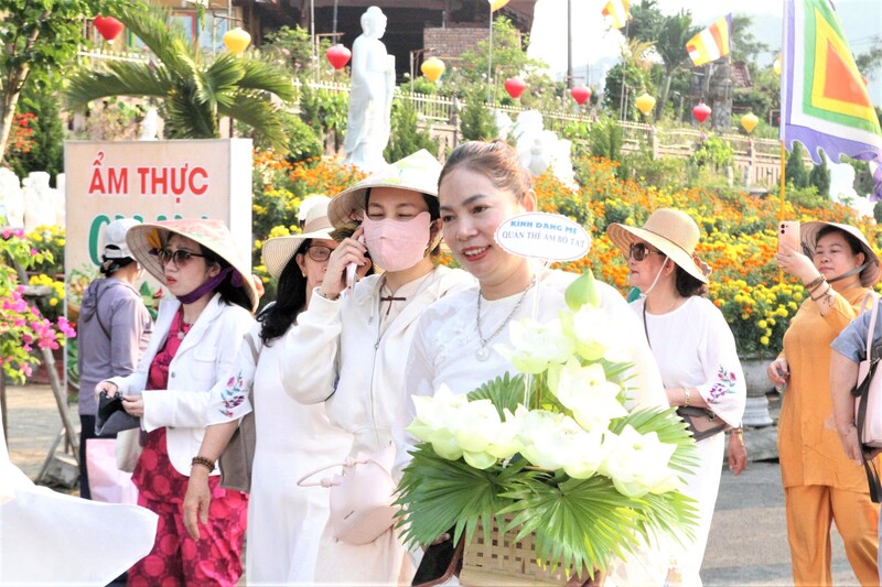 Các phật tử đến chiếm bái dâng hoa kính mừng. Ảnh: Diễm Phúc