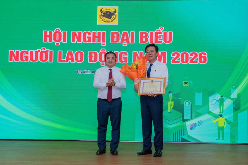 Ông Phùng Quang Hiệp, Chủ tịch Hội đồng thành viên Vinachem trao danh hiệu thi đua đến ông Ngô Văn Đông, Bí thư Đảng ủy, Tổng giám đốc Công ty CP Phân bón Bình Điền.