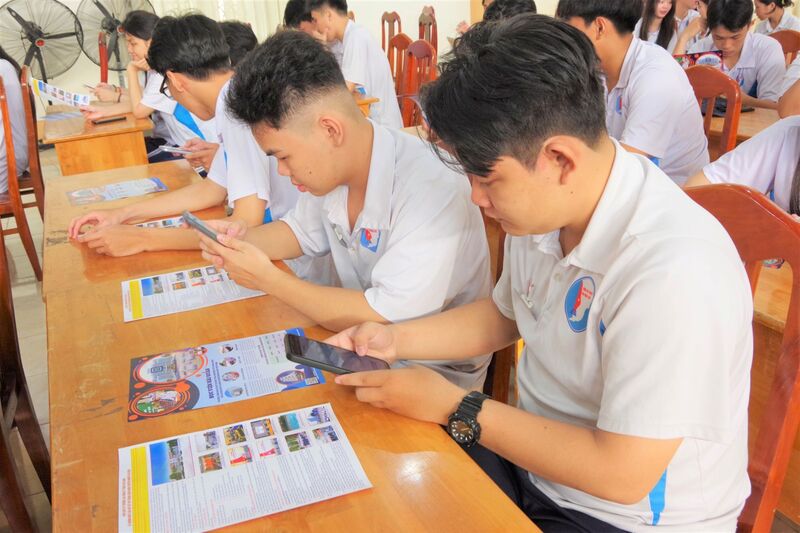 Học sinh sử dụng điện thoại thông minh quyết mã QR trên tờ rơi tuyển sinh, để tra cứu các nội dung tuyển sinh vào Học viện Hải quân năm 2026. Ảnh: Huy Tứ