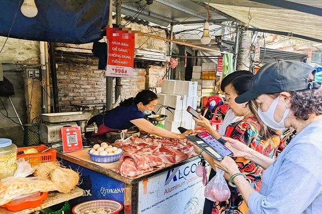 Việc sử dụng mã QR để thanh toán đã trở nên quen thuộc tại các chợ truyền thống. Ảnh minh hoạ