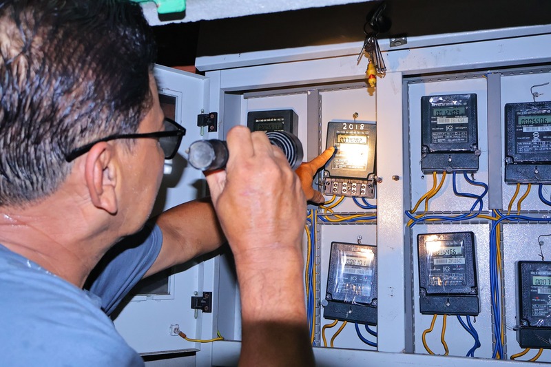 Ông Dũng thường xuyên kiểm tra số điện tiêu thụ của các hộ dân để kịp cảnh báo, tránh tình trạng điện tăng bất ngờ do chập, hở mạch. Ảnh: Diễm Phúc