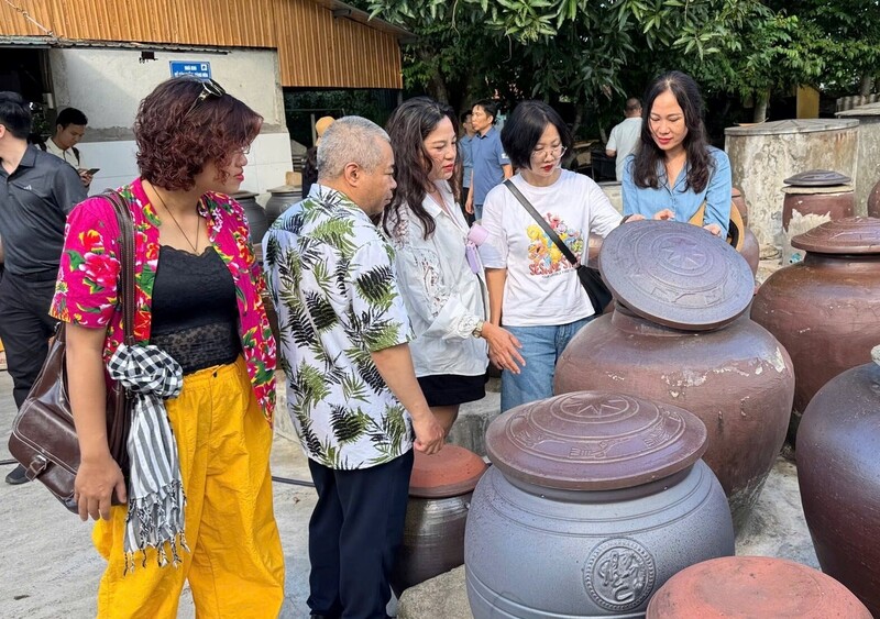 Khách du lịch tham quan các cơ sở chế biến nước mắm ở làng nghề Hải Giang 1 (phường Cửa Lò)  Anh: Thanh Phúc