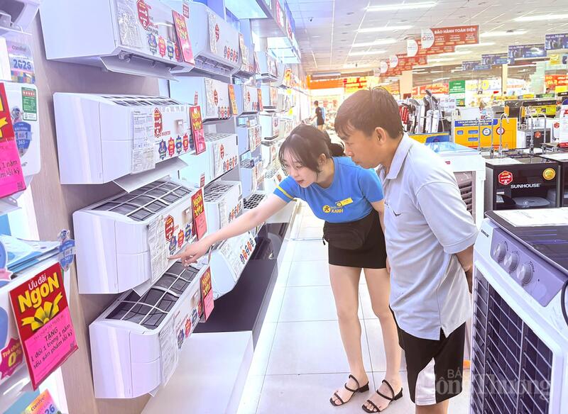 Nhân viên siêu thị Điện Máy Xanh trên đường Tô Ký giới thiệu các máy lạnh tiết kiệm điện cho khách hàng. Ảnh: Thanh Minh.