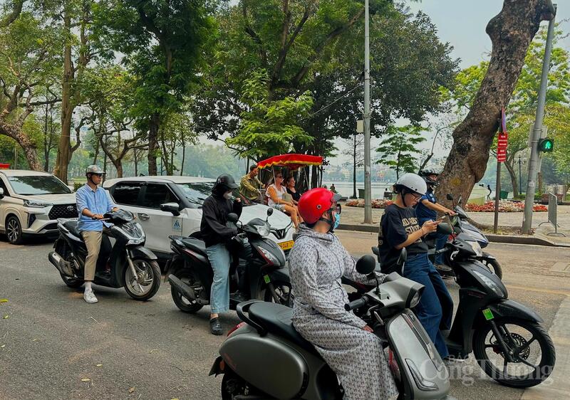 Người dân trang bị đồ bảo hộ kín mít để chống chọi với đợt nắng nóng cao điểm đầu mùa tại khu vực trung tâm Hà Nội.