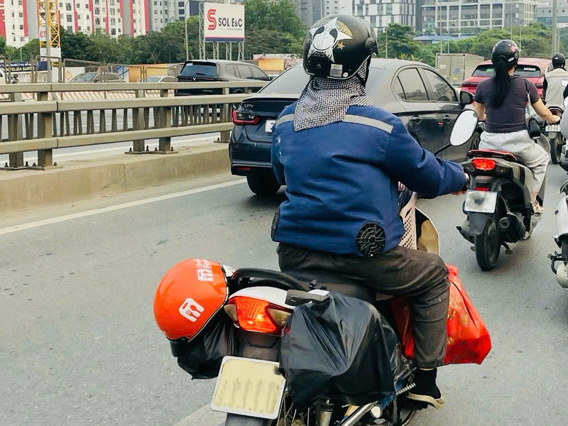 Không khó để bắt gặp hình ảnh người dân lao động mặc áo điều hoà trong thời tiết nắng nóng gay gắt. Ảnh: Nhật Chi