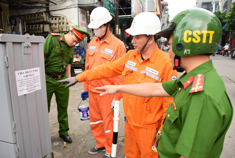 EVNHANOI phối hợp với lực lượng chức năng rà soát tủ điện có dấu hiệu tái vi phạm dán quảng cáo tại phường Ô Chợ Dừa.