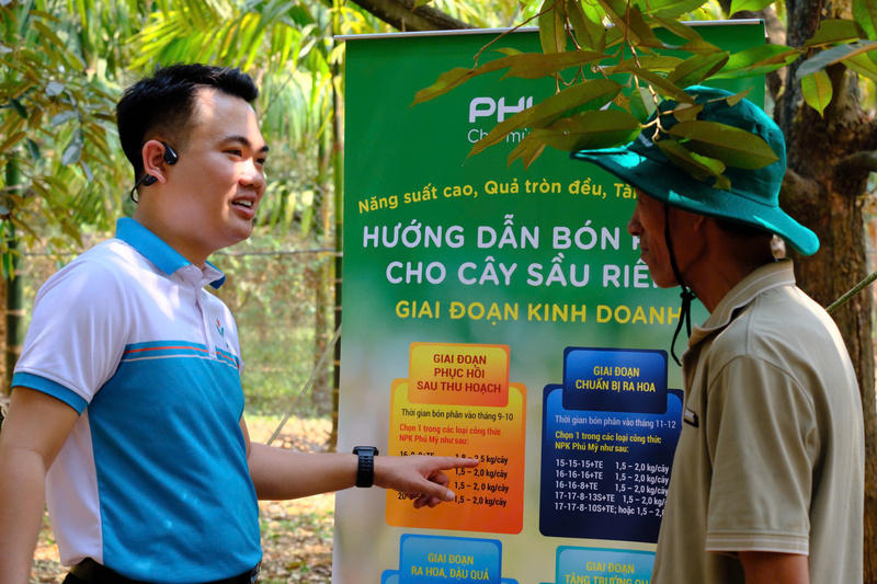Chuyên gia nông nghiệp Phú Mỹ hướng dẫn người nông dân bón phân đúng, đủ trên cây sầu riêng. Ảnh: PVFCCo