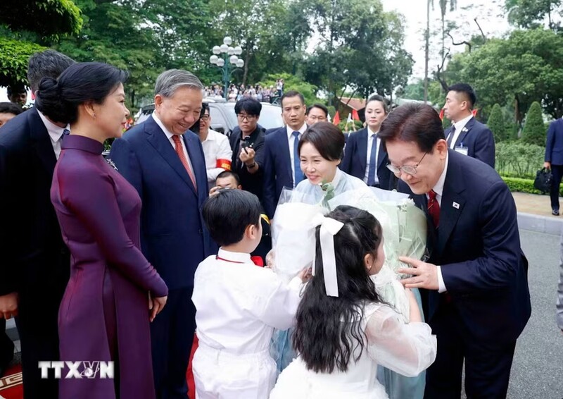 Các cháu thiếu nhi Thủ đô tiến tới trao tặng Tổng thống Lee Jae Myung và Phu nhân những bó hoa tươi thắm. Ảnh: Thống Nhất/TTXVN