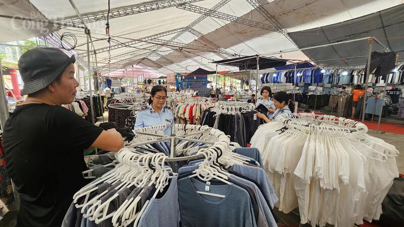 Đội Quản lý thị trường số 19 kiểm tra nguồn gốc xuất xứ hàng hóa trong các quầy hàng quần áo được bày bán trong không gian lễ hội chùa Thầy. Ảnh: Văn Thi