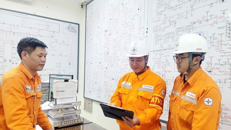 Anh Dương Văn Bình (đứng giữa) cùng đồng nghiệp kiểm tra phương án bảo đảm an toàn trước khi làm việc trên lưới điện. Ảnh: Thanh Ngọc