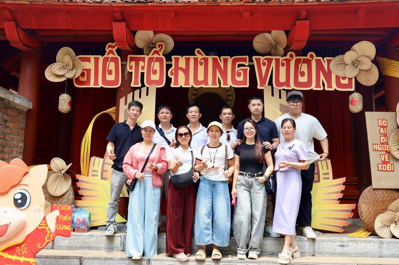 Du khách chụp ảnh lưu niệm tại không gian trưng bày chủ đề Giỗ Tổ Hùng Vương.