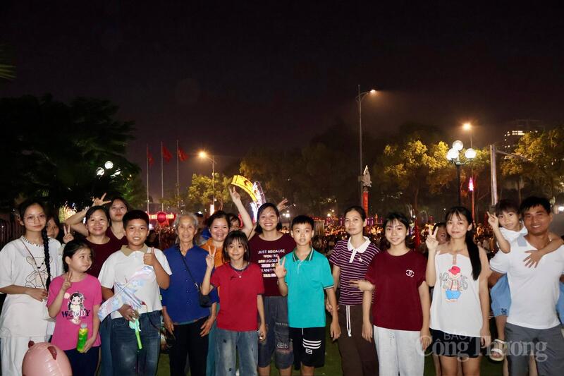 Cụ Lê Thị Sơn (mặc áo xanh, đứng thứ sáu từ bên trái qua) cùng con cháu có mặt từ sớm tại khu vực Công viên Văn Lang để xem pháo hoa. Ảnh: Phương Hà