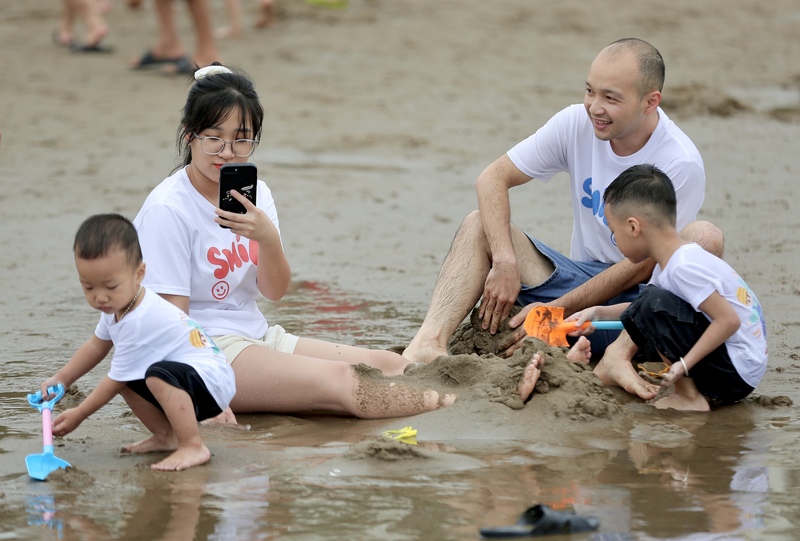 Nhiều gia đình dựng lều, trải thảm trên bãi cát để nghỉ ngơi, ăn uống. Trẻ nhỏ vui chơi với cát, người lớn thư giãn dưới gió biển. Những khoảnh khắc sum vầy, gắn kết trở thành điểm nhấn đáng nhớ trong hành trình nghỉ lễ tại Sầm Sơn. Anh Diêm Hướng Bộ (du khách đến từ Bắc Ninh) cho biết, hàng năm gia đình anh cũng tổ chức đi biển Sầm Sơn. Tuy nhiên, năm nay lượng khách về đây rất đông tạo nên bầu không khí cực kỳ sôi động. Ảnh: Ngô Nhung