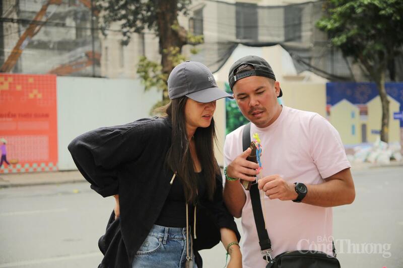 Du khách nước ngoài chăm chú tìm hiểu các trò chơi và nét văn hóa dân gian Việt Nam. Sự tò mò và thích thú hiện rõ trong từng ánh nhìn, góp phần làm nên bức tranh giao thoa văn hóa sống động giữa lòng Thủ đô. Ảnh: Minh Hương