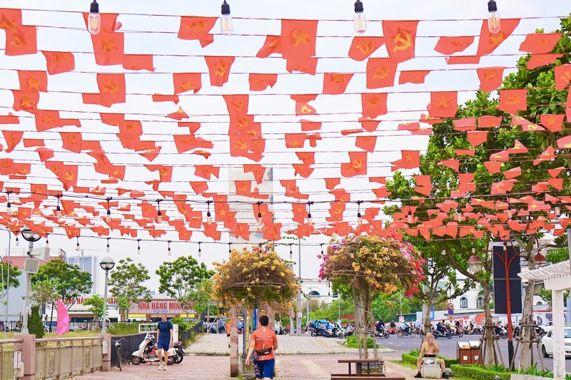 Nhiều tuyến đường trung tâm như Bạch Đằng, Nguyễn Văn Linh, Trần Hưng Đạo... được trang hoàng đồng bộ với cờ hoa, khẩu hiệu và cụm tiểu cảnh nổi bật. Ảnh: Diễm Phúc