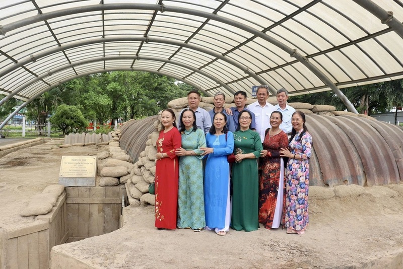 Người dân và du khách chụp ảnh lưu niệm tại Di tích hầm Đờ Cát và thưởng lãm các bức ảnh nghệ thuật về Chiến thắng Điện Biên Phủ. Ảnh: CTV