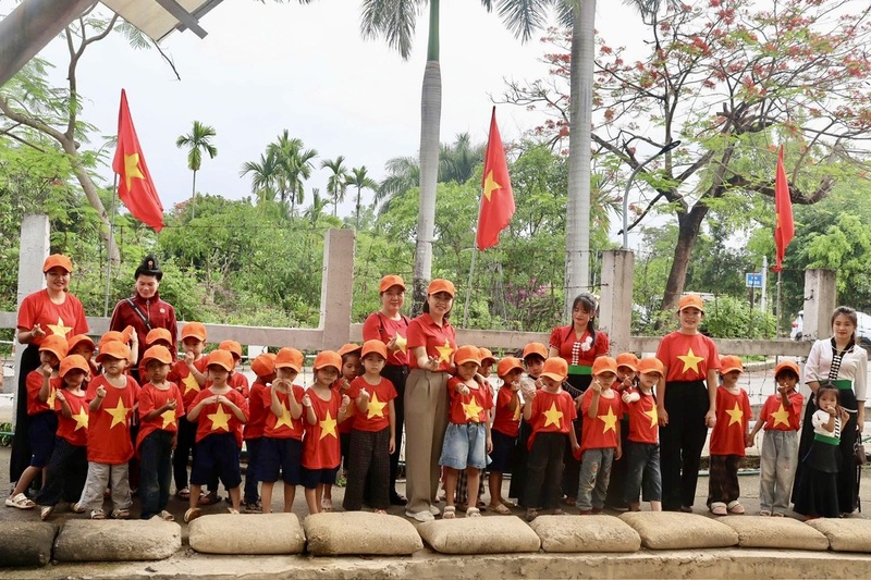 Giáo viên và học sinh chụp ảnh lưu niệm tại Di tích hầm Đờ Cát. Ảnh: CTV