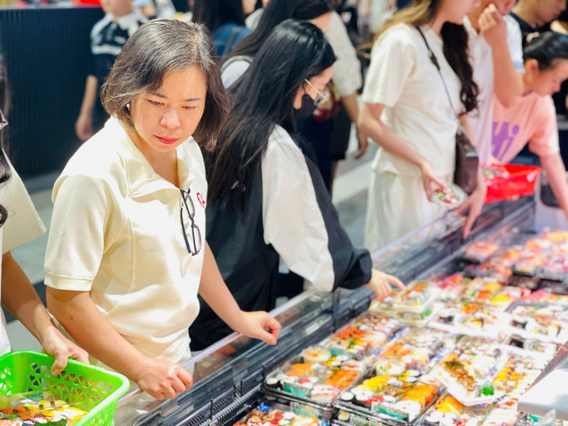 Khu ẩm thực phục vụ đầy đủ các món ăn Nhật Bản, nhiều món đóng gói sẵn cũng trở thành lựa chọn ‘nhanh - gọn - lẹ’ cho một buổi tối, chị Phan Thanh Hằng (áo trắng) cho biết: “Ngày nghỉ lễ, tôi cùng 2 con vào trung tâm thương mại chơi, các bạn ấy thích ăn những thứ nhanh gọn nên mẹ cũng chiều, vả lại đồ ăn nhìn rất sạch sẽ, đẹp mắt. Dù hơi đông người một chút và các hàng ghế ngồi gần như kín chỗ nhưng ngày lễ mà, đành chịu thôi”. Ảnh: Mai Linh