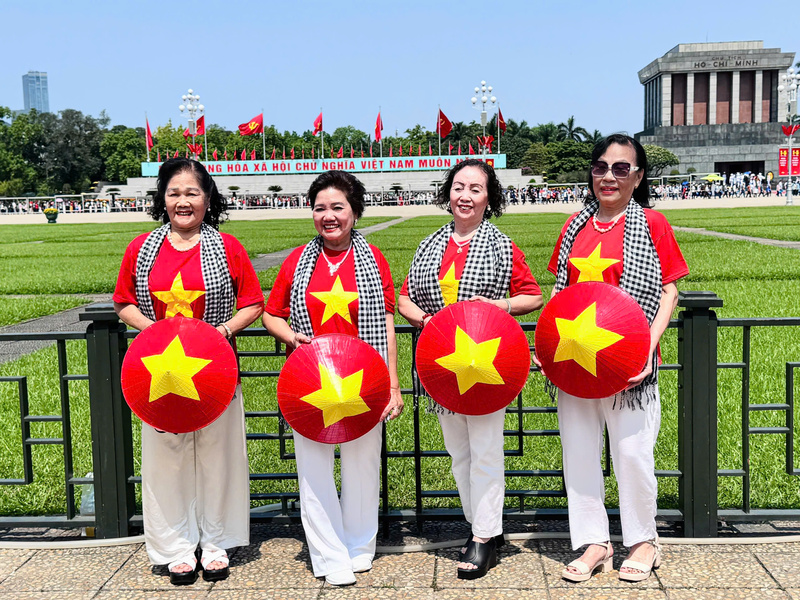 Tại Quảng trường Ba Đình rực rỡ cờ hoa, sắc đỏ của áo cờ Tổ quốc nổi bật giữa dòng người, xen lẫn hình ảnh những tà áo dài thướt tha trong gió. Ảnh: Nhật Chi