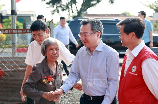 Đồng chí Nguyễn Thanh Nghị (thứ 2, từ phải sang) thăm hỏi, động viên gia đình bà Lương Thị Thân, thanh niên xung phong bị nhiễm chất độc hóa học tại thôn 9 Tâm Thắng, xã Cư Jút, tỉnh Lâm Đồng. Ảnh: TTXVN