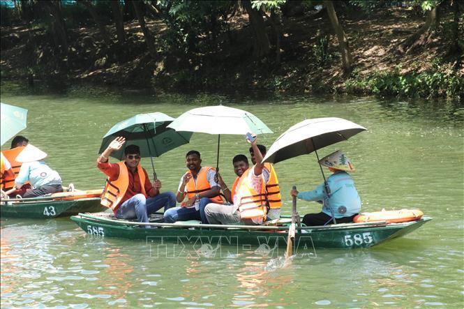 Những vị khách đầu tiên trong đoàn 4.500 khách của tỉ phú Ấn Độ thăm quan Khu du lịch sinh thái Tràng An, Ninh Bình. Ảnh: Hải Yến/TTXVN
