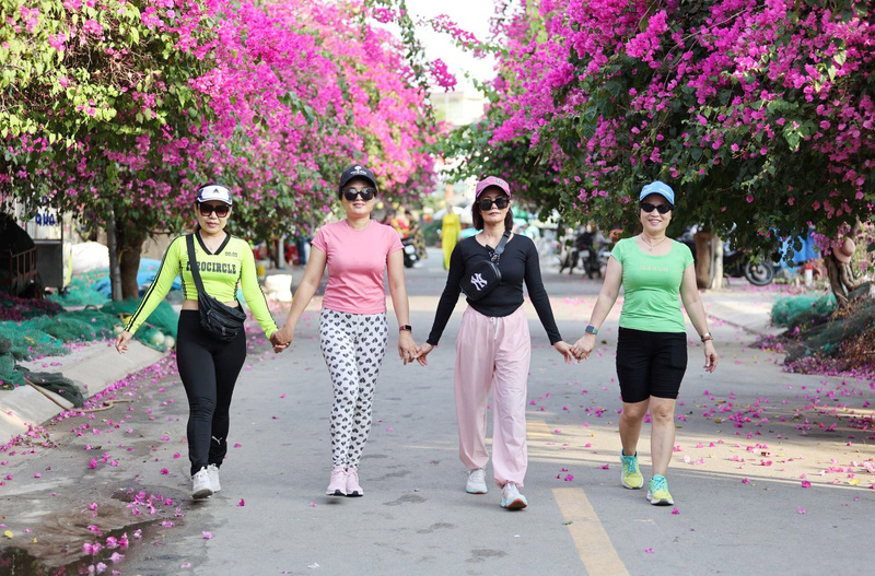 Người dân Nha Trang đi dưới con đường rực rỡ sắc màu hoa.