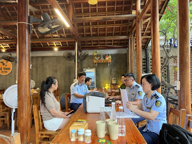Lực lượng chức năng kiểm tra và lập biên bản đối với cơ sở kinh doanh dịch vụ ăn uống mà không có Giấy chứng nhận cơ sở đủ điều kiện an toàn thực phẩm. Ảnh: Hoàng Minh