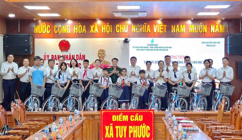 Đoàn đại biểu Quốc hội tỉnh phối hợp với Tập đoàn Công nghiệp - Năng lượng Quốc gia Việt Nam và Tổng công ty Phân bón và Hóa chất Dầu khí trao tặng xe đạp cho học sinh xã Tuy Phước. Ảnh: Hiền Mai