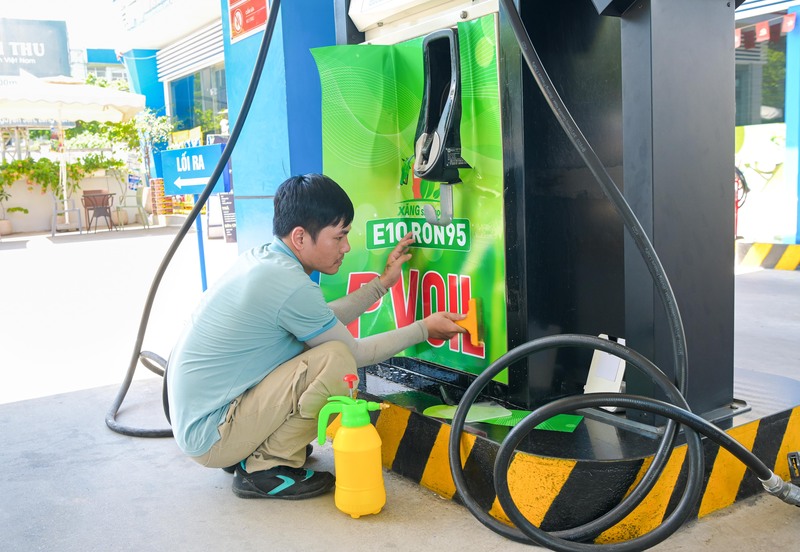 Đơn vị thi công dán nhãn sản phẩm xăng E10 tại trụ bơm. Ảnh: PVOIL