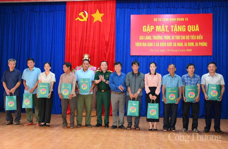 Thượng tá Phạm Xuân Tri, Đoàn trưởng Đoàn KT-QP 72 và ông Trần Ngọc Phận, Bí thư Đảng uỷ xã Ia Dom (thứ 7 từ trái qua) trao quà tặng cho già làng, trưởng thôn, bí thư chi bộ tiêu biểu trên địa bàn.