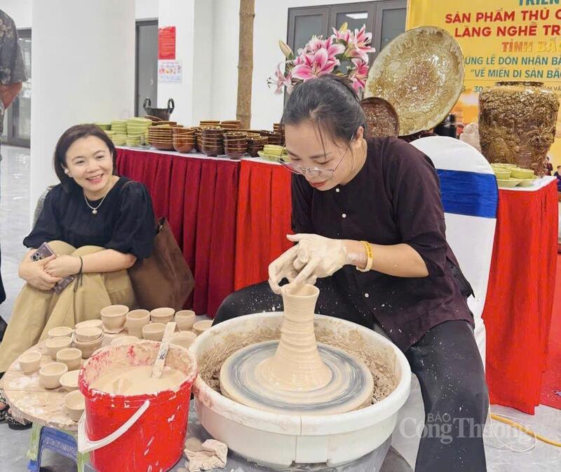 Chị Đặng Thị T&acirc;m giới thiệu đến kh&aacute;ch h&agrave;ng về quy tr&igrave;nh l&agrave;m gốm. Ảnh: NH