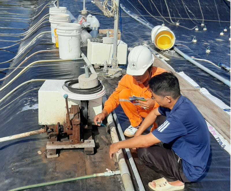 Nhân viên Công ty Điện lực Cà Mau tuyên truyền sử dụng điện an toàn, tiết kiệm trong nuôi tôm. Ảnh: PC Cà Mau