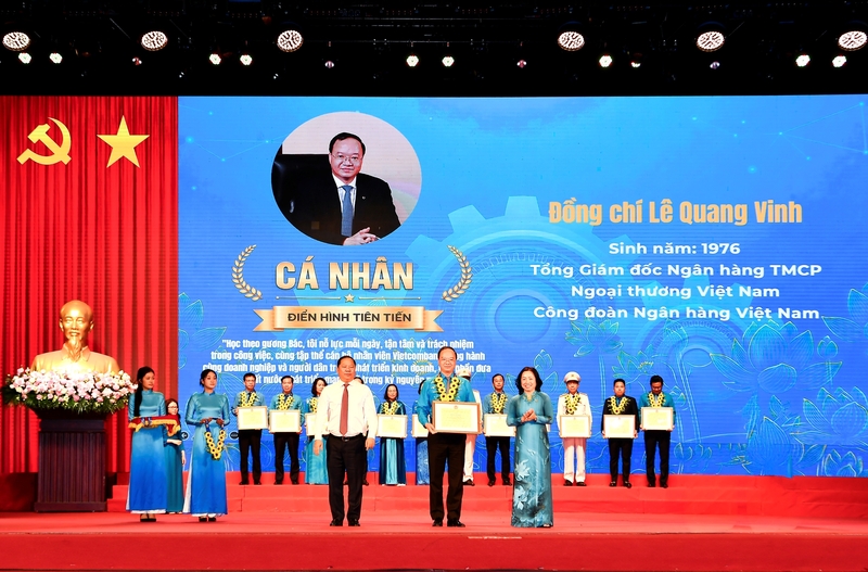 Ông Nguyễn Phi Long, Phó Chủ tịch Ủy ban Trung ương Mặt trận Tổ quốc Việt Nam (bên trái) trao hoa chúc mừng và bà Thái Thu Sương - Phó Chủ tịch thường trực Tổng Liên đoàn Lao động Việt Nam (bên phải) trao bằng khen cho ông Lê Quang Vinh. Ảnh: Lê Hồng Quang