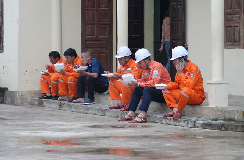 Bữa cơm vội tại hiện trường của cán bộ, nhân viên trong chiến dịch giảm tổn thất điện năng. Ảnh: Phan Thủy