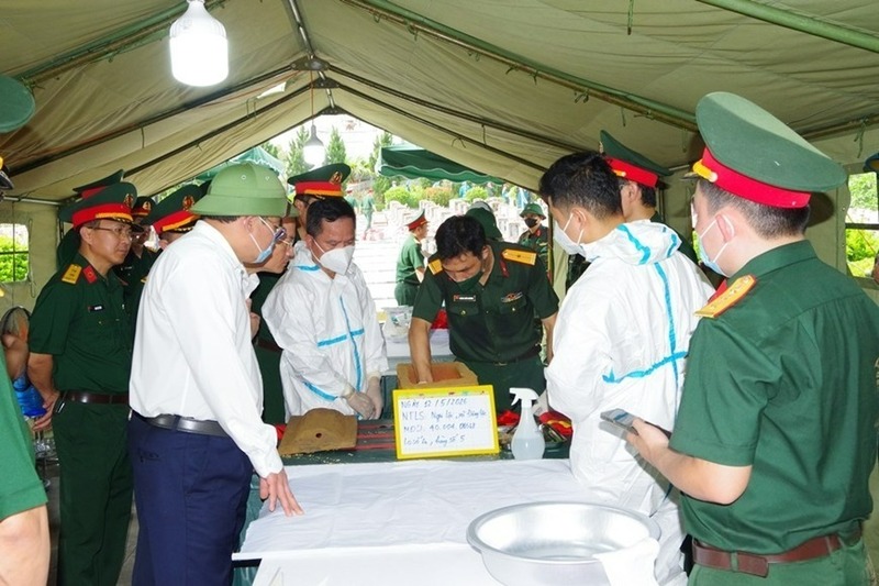 Lực lượng chức năng lấy mẫu sinh phẩm hài cốt liệt sĩ chưa xác định được danh tính để giám định ADN. Ảnh: Hoa Lê