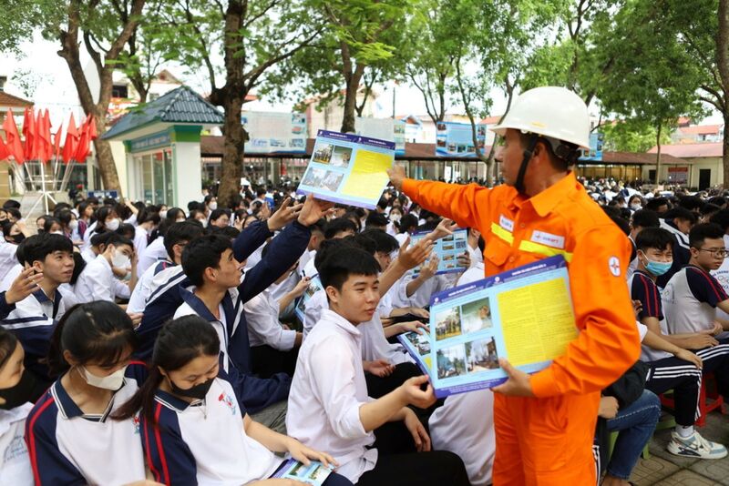 Cán bộ công nhân viên EVNNPT phát tờ rơi tuyên truyền không thả diều, vật bay gần lưới điện cao áp . Ảnh: EVNNPT