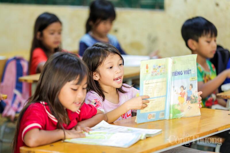 Ở phía trước lớp, chiếc bảng đã bạc màu, những chiếc quạt treo tường vẫn quay đều giữa cái nóng oi ả vùng biên. Dù vậy, học sinh vẫn chăm chú nghe giảng, nhiều em nắn nót từng nét chữ trên những cuốn vở đã sờn mép và thêm tiếng trẻ con ê a đánh vần vang lên khiến không gian nơi đây thêm đặc biệt.
