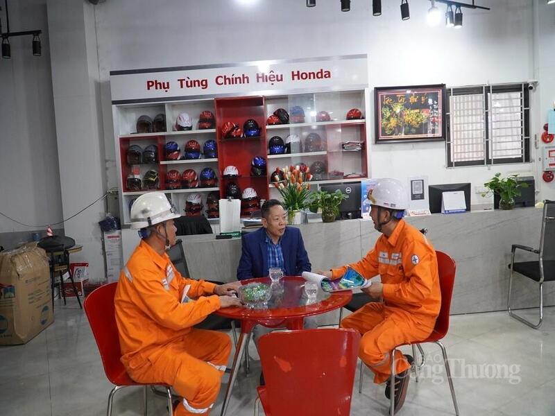 Công nhân Công ty Điện lực Quảng Ninh tuyên truyền người dân, hộ kinh doanh tiết kiệm điện. Ảnh: Ngọc Lan