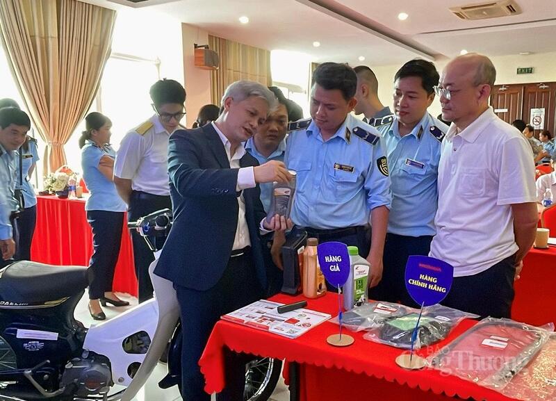 Các đại biểu tham quan gian hàng trưng bày phân biệt hàng thật - hàng giả trên sản phẩm thực tế tại hội nghị.