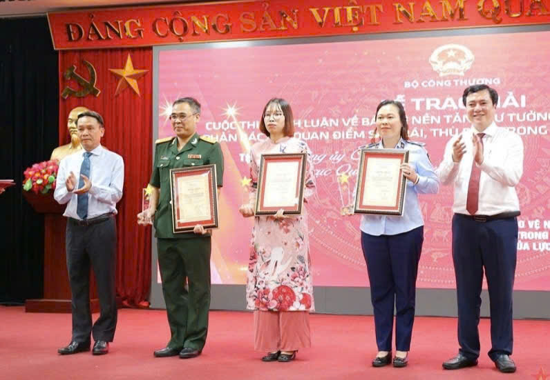 Thứ trưởng Bộ Công Thương Nguyễn Sinh Nhật Tân (ngoài cùng bên phải) trao giải cho các tác giả đoạt giải Nhì Cuộc thi chính luận bảo vệ nền tảng tư tưởng của Đảng trong ngành Công Thương năm 2023. Ảnh: CT