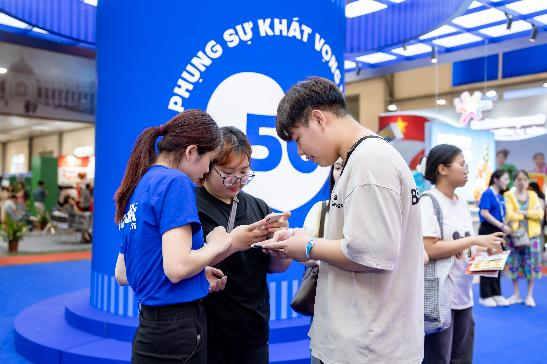 Khách tham quan tương tác tại khu vực “trái tim phụng sự” để khám phá câu chuyện 50 năm của Vinamilk (Ảnh: Duy Cường).