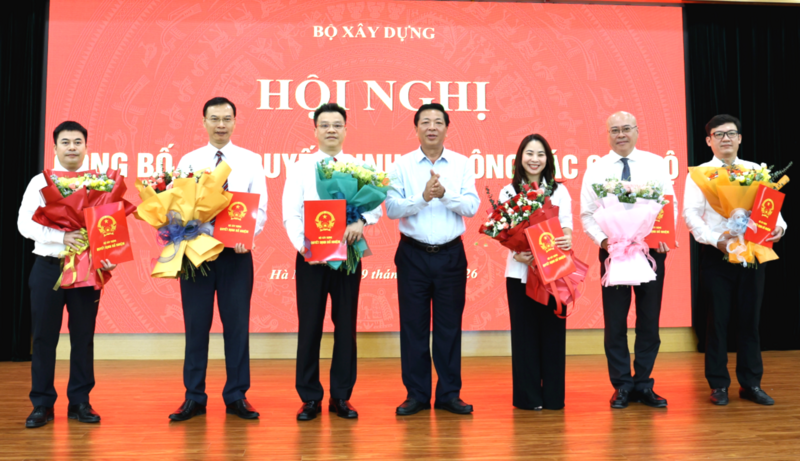 Bộ trưởng Bộ Xây dựng Trần Hồng Minh trao quyết định và tặng hoa các cán bộ được bổ nhiệm, bổ nhiệm lại tại Hội nghị sáng 29/5. Ảnh: Báo Xây dựng
